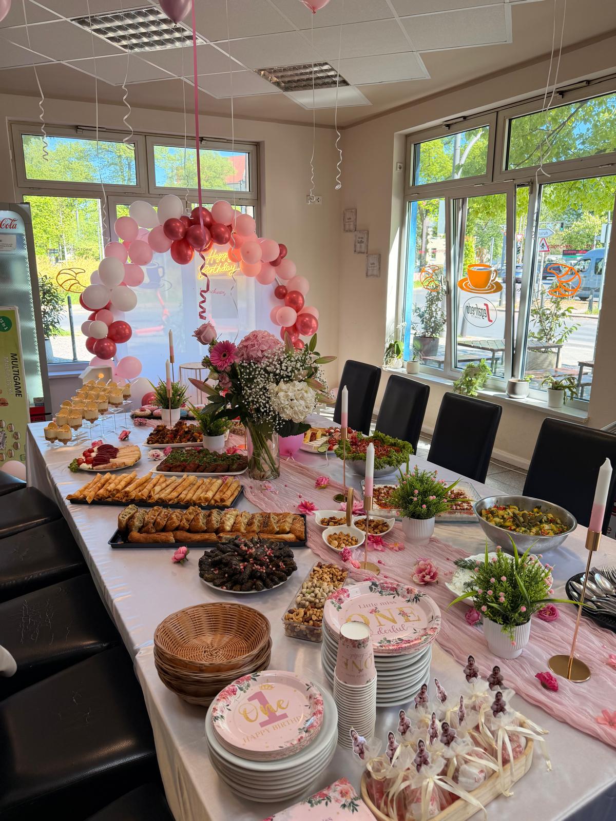 Rosa dekoriertes Buffet mit Blumen und orientalischen Spezialitäten zum ersten Geburtstag